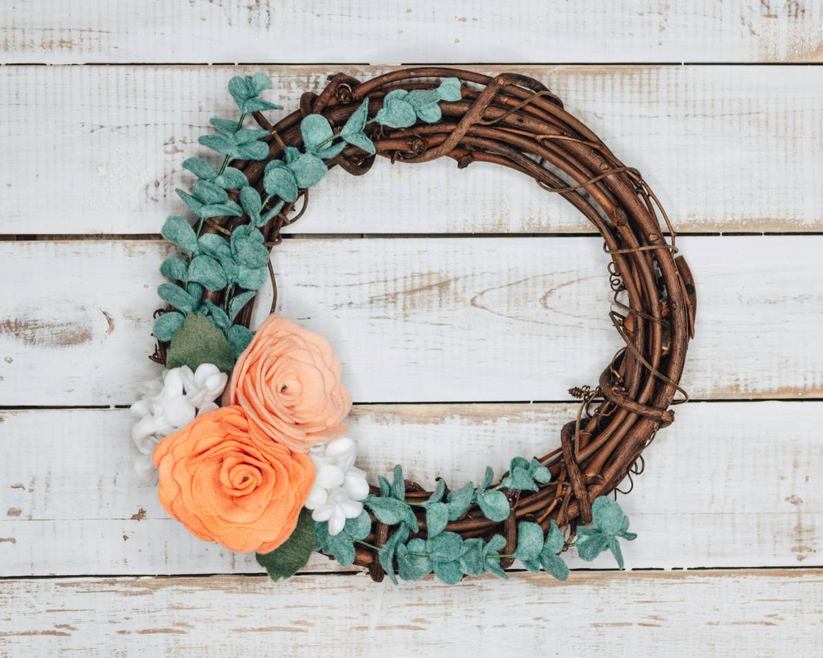 Handcrafted wreaths with flowers and deco mesh on rustic front door
