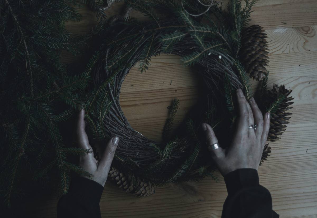 Close-up of decorating christmas wreaths ideas showing zip-tied ornaments on a metal frame base